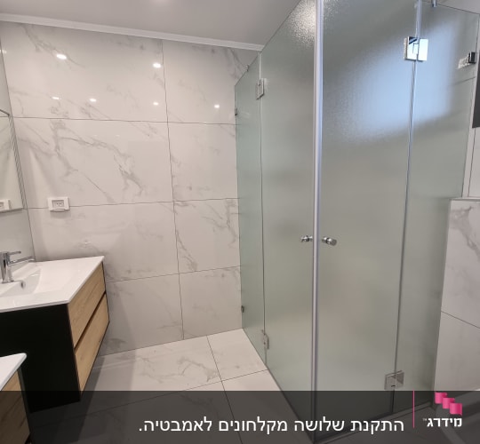 מקלחון זכוכית עם דלתות שקופות בחדר אמבטיה